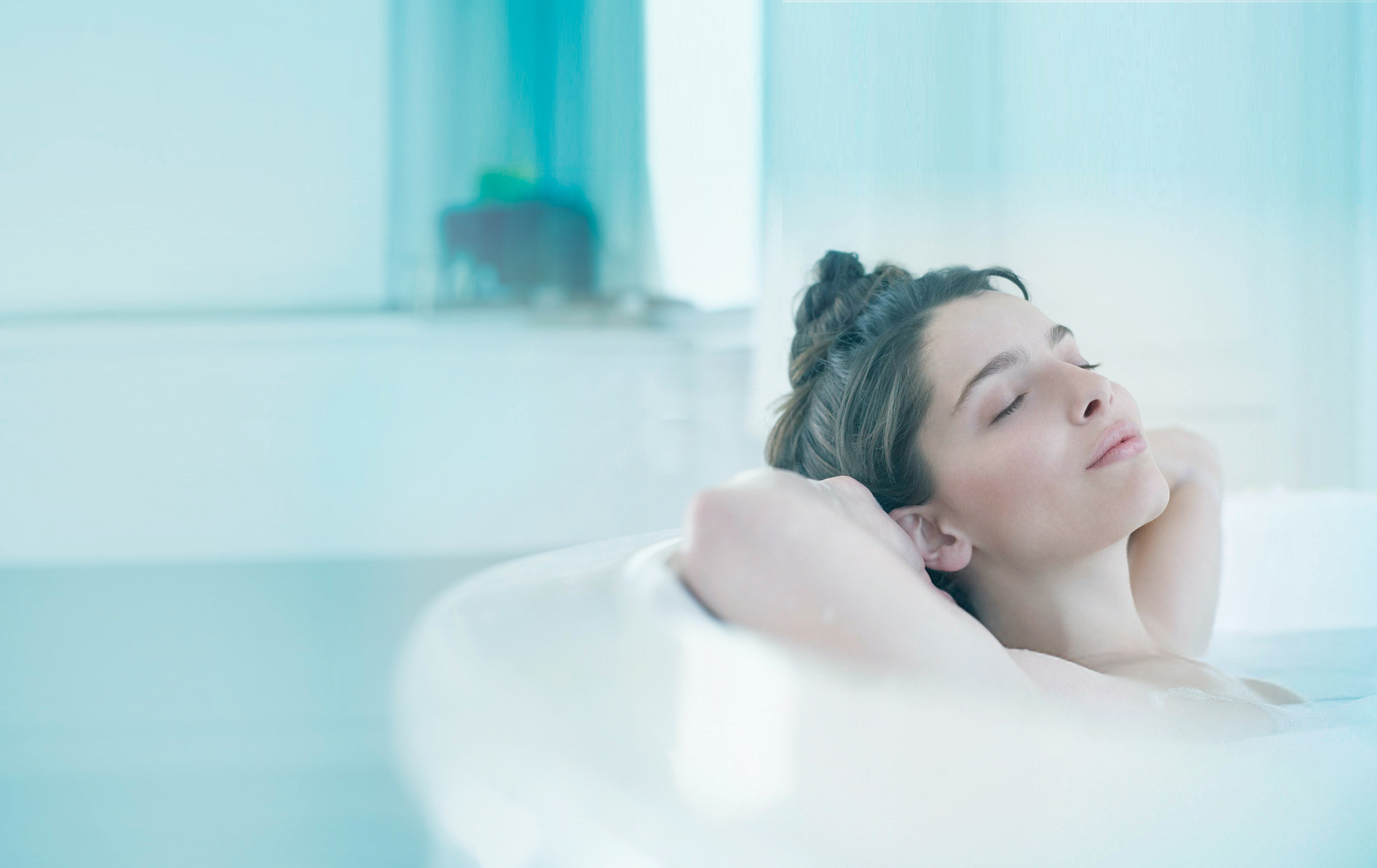 A woman enjoys a relaxing full bath in a bathtub