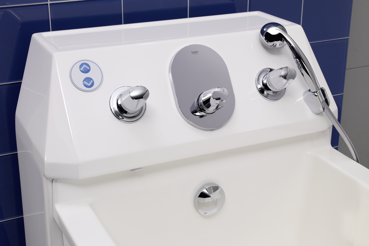 At the desk of the bath are located filling, hand shower and height adjustment. 