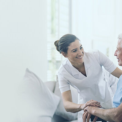 A nurse kindly cares for an elderly man in a wheelchair